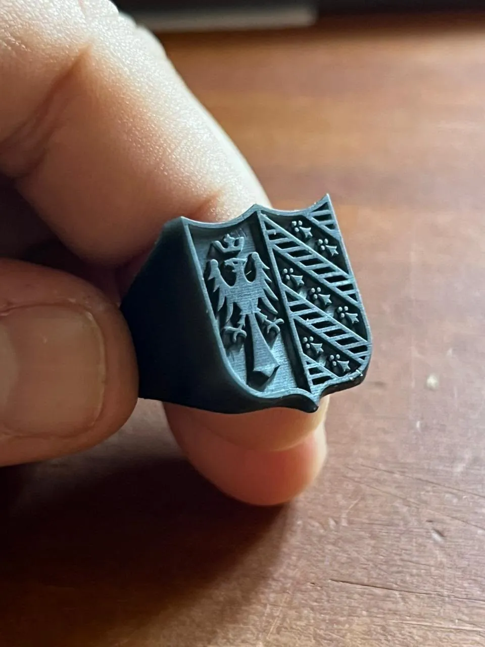 El anillo sello impreso en resina de alto detalle, sostenido en la mano
