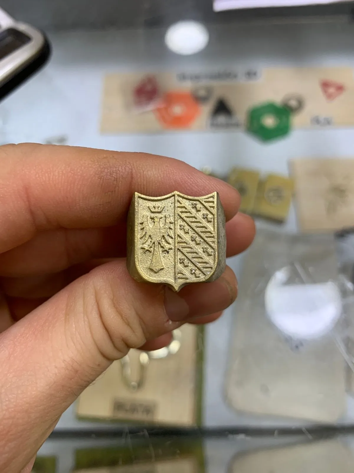 El anillo sello terminado en metal, sostenido en la mano